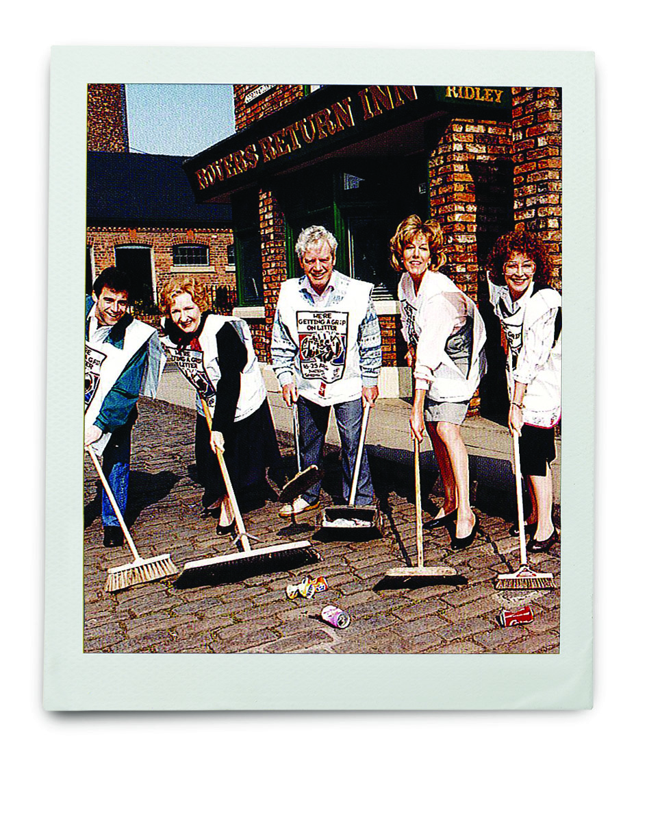 An image of 5 people holding brooms