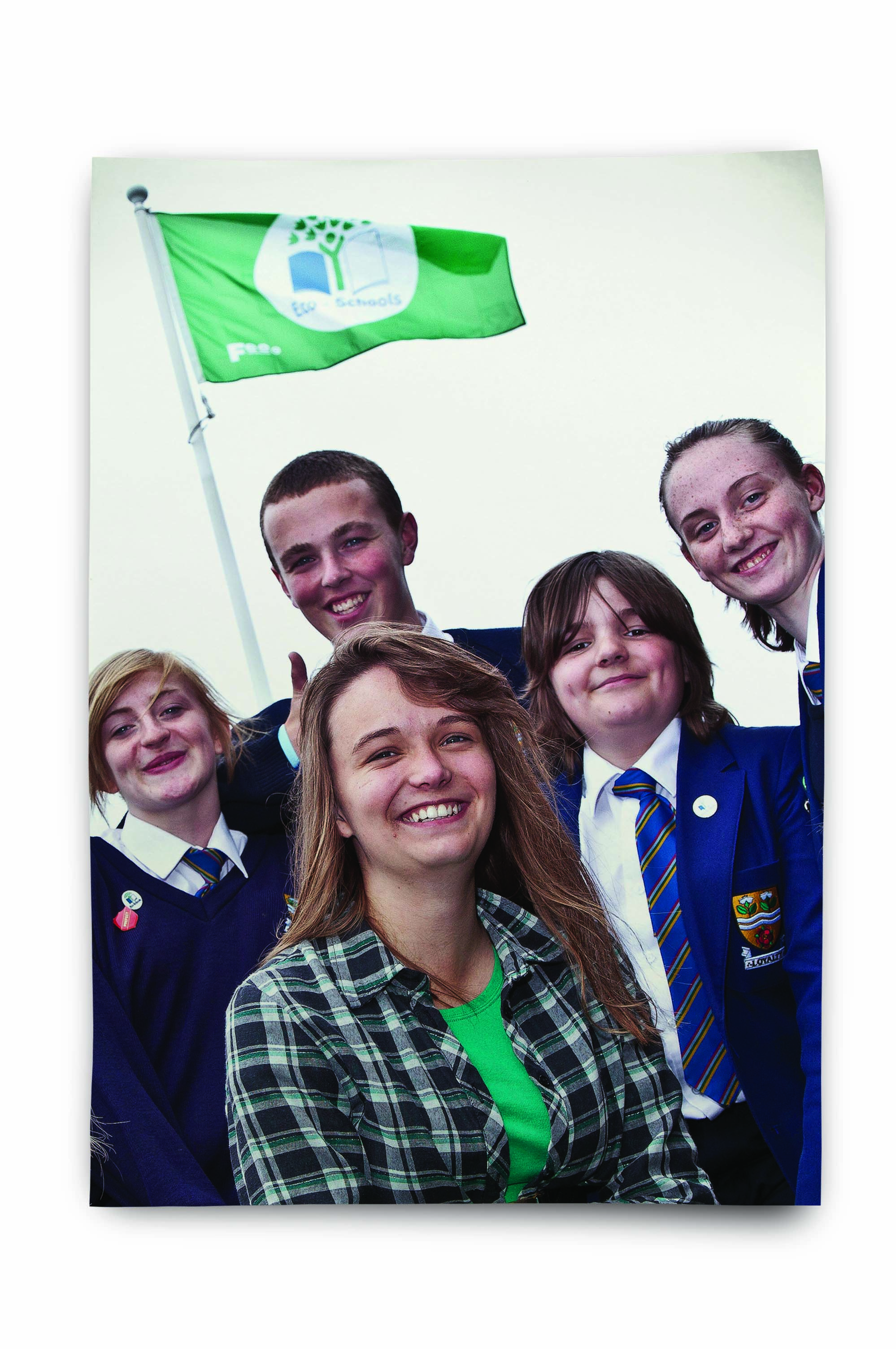 An image of a teacher and school children in front of an Eco-Schools flag