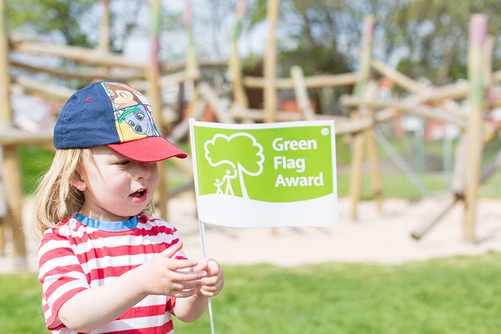 An image of a child holding a Green Flag