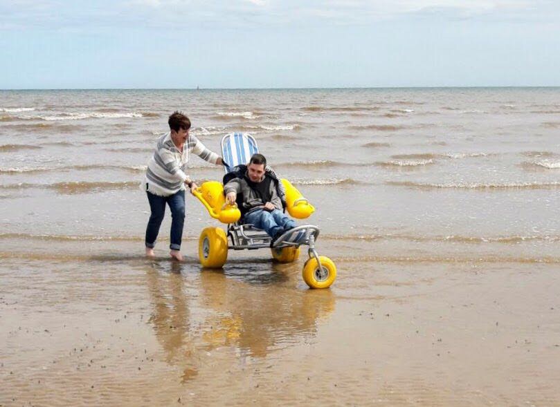 An image of a gentleman using a beach wheelchair