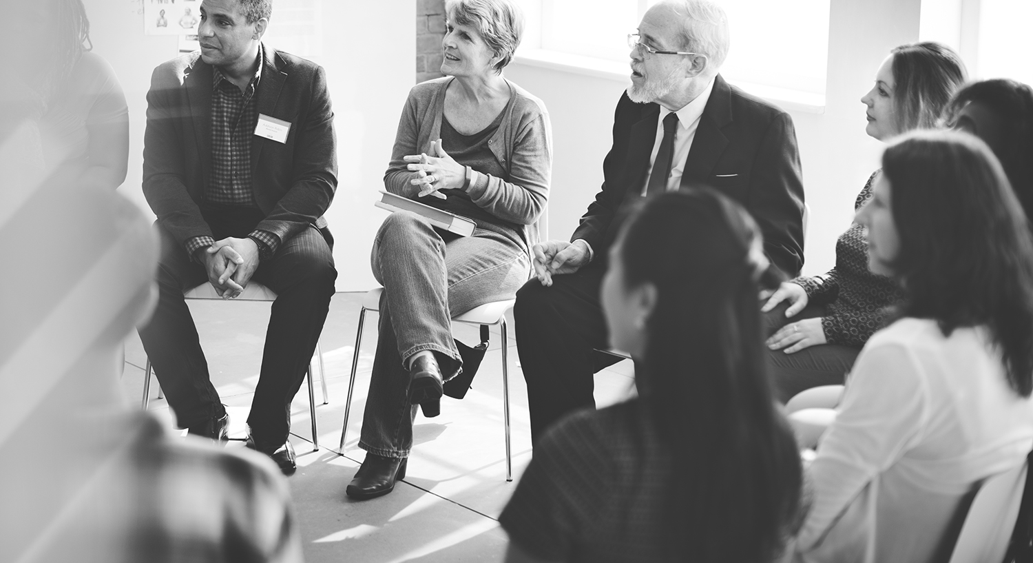 An image of people sitting around at a meeting