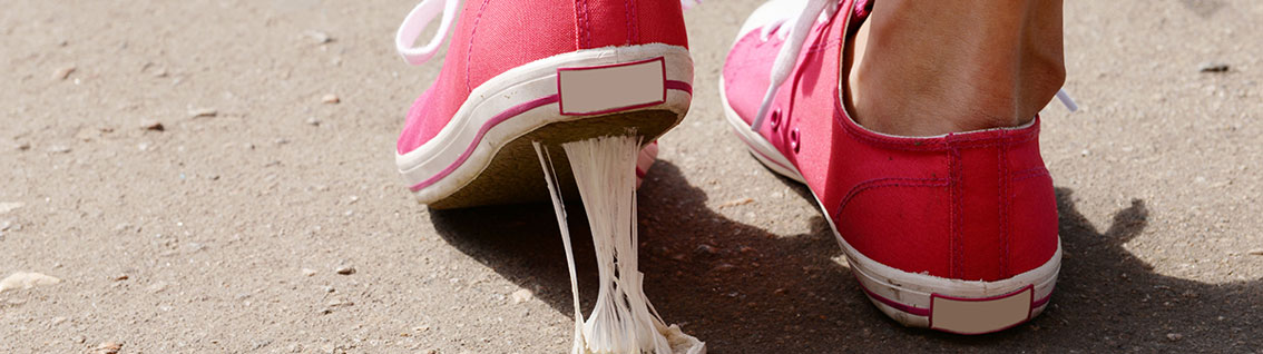 An image of pink trainers stepping in chewing gum