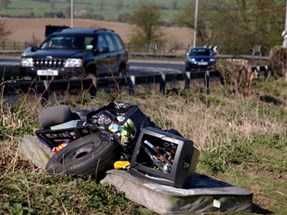 An image of fly tipping and a car driving past it