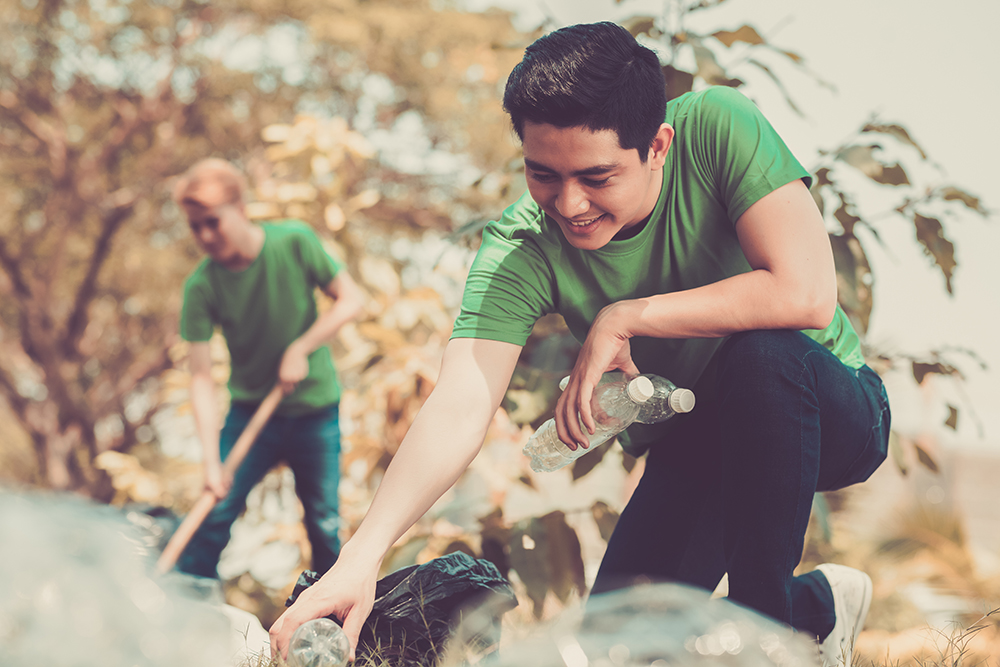 An image of a man picking up litter from the ground