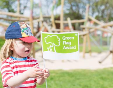 An image of a child holding a Green Flag