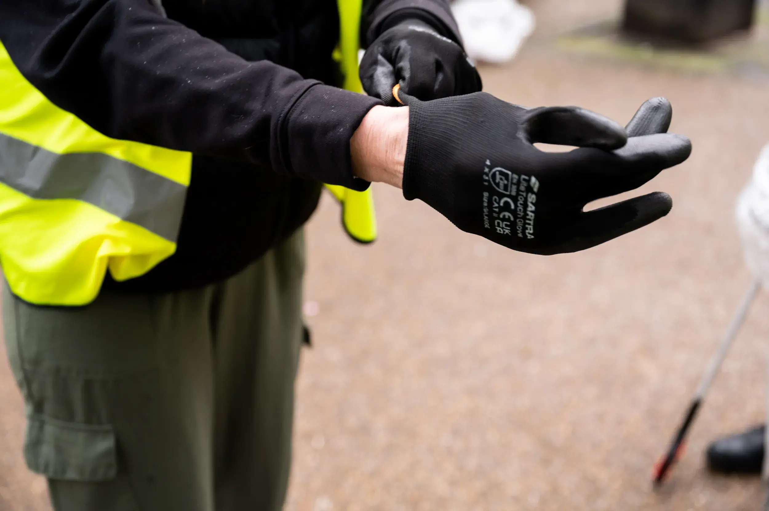 Litter picker putting on black glove