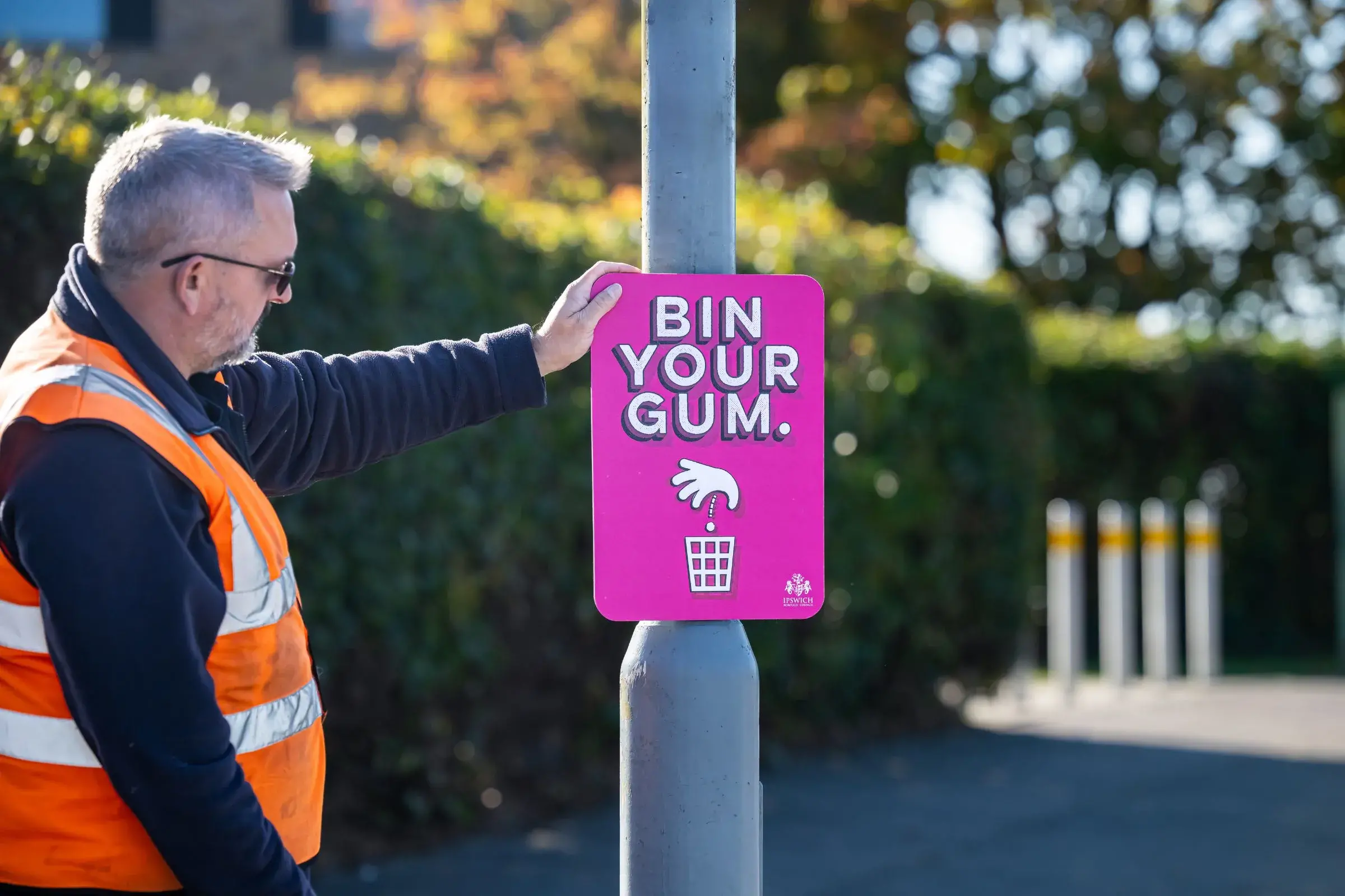 Council street scene worker inspecting gum litter prevention signage