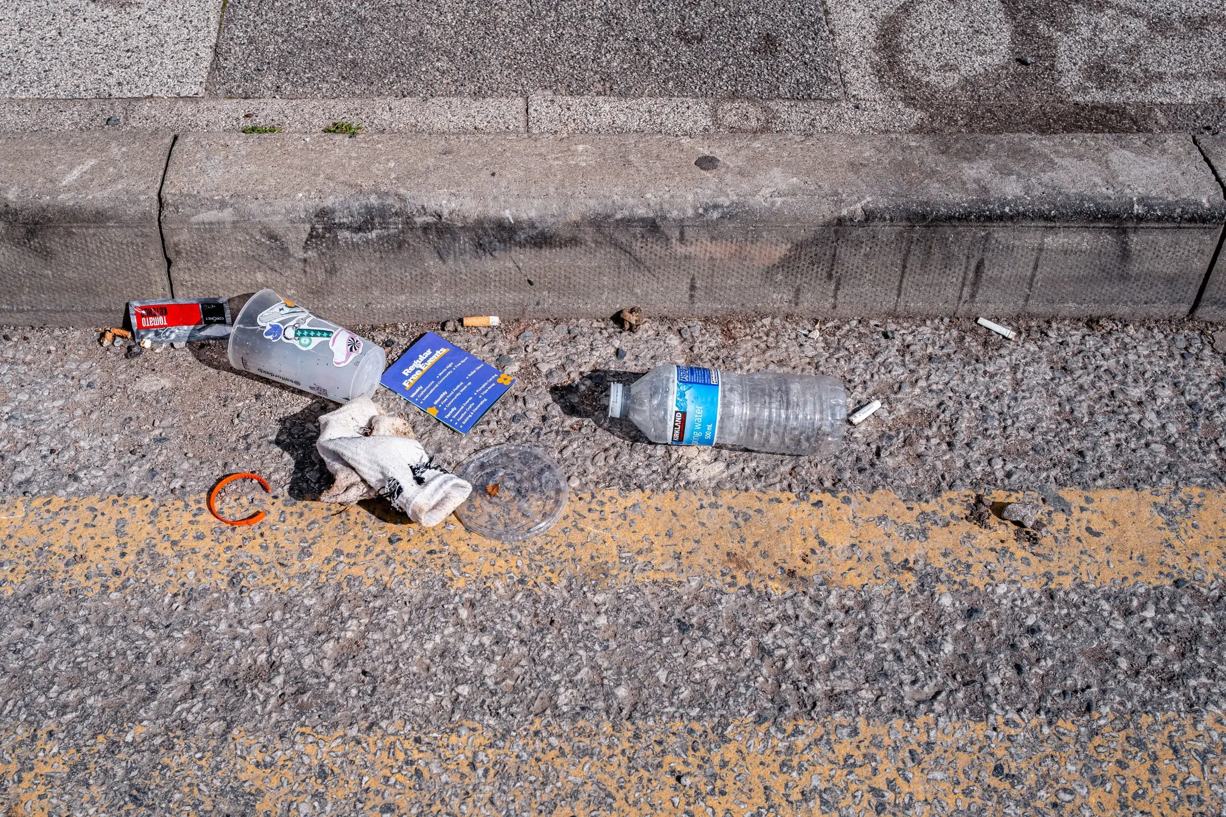 Litter laying in road beside the pavement