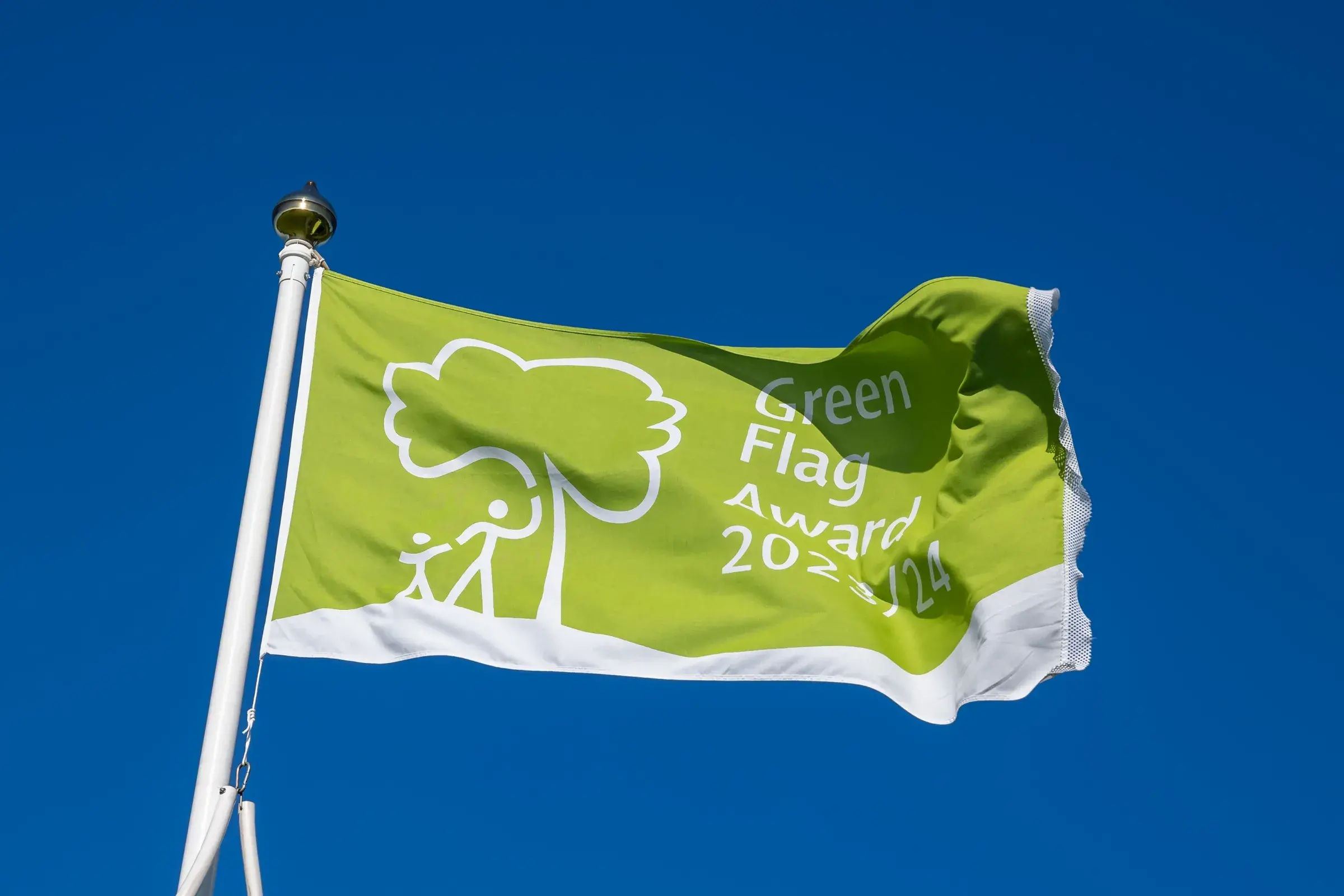 Green Flag Award flag flying against a vivid blue sky