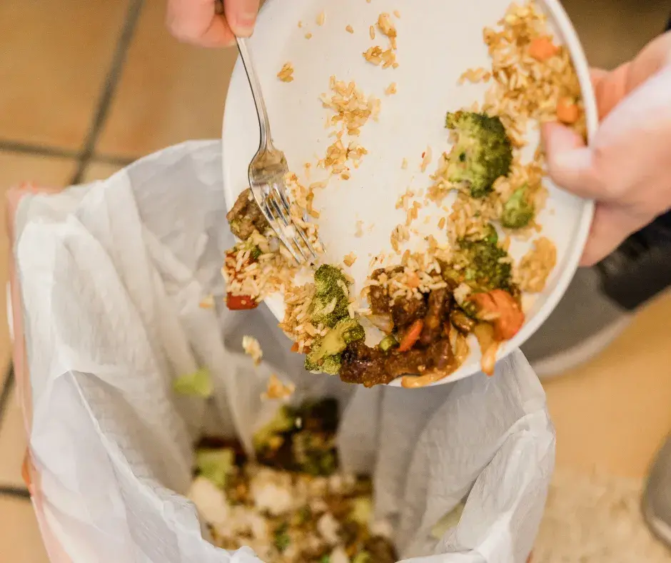 Food waste being scraped into a bin