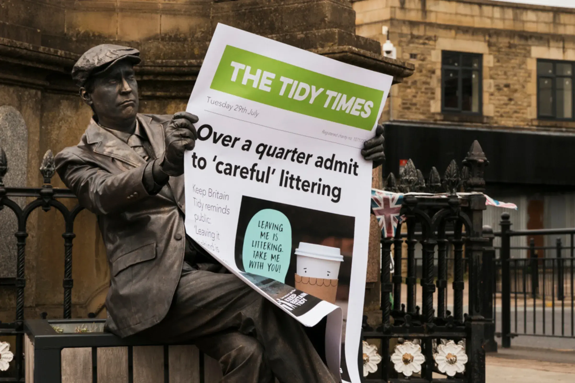 Human statue holding giant newspaper promoting our careful littering campaign