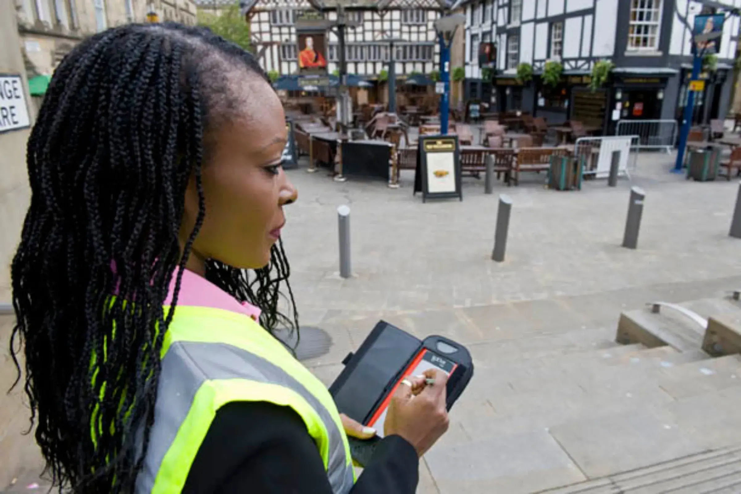 Surveyor inspecting the environmental quality of a town street using a mobile device